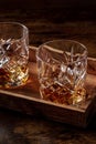 Whiskey in glasses with ice. Bourbon whisky on rocks on a dark wooden table Royalty Free Stock Photo