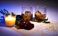 Whiskey in glasses with ice cubes , flowers and candle