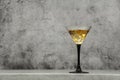 Whiskey with ice or brandy in a glass on a background of gray concrete on an old wooden table. Whiskey with ice in a glass. Whiske