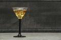 Whiskey with ice or brandy in a glass on a background of gray concrete on an old wooden table. Whiskey with ice in a glass. Whiske