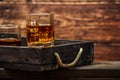 Whiskey with ice or brandy in a glass and a square carafe on an old wooden background. Whiskey with ice in a glass. Whiskey or cog Royalty Free Stock Photo