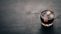 Whiskey with ice in a glass. Rum-Cola. Brandy. On a black wooden background. Royalty Free Stock Photo