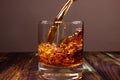 Whiskey is poured into a glass. Fiery high-end alcoholic drink