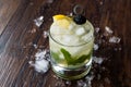 Whiskey Smash Cocktail with Mint Leaves, Lemon, Olive and Crushed Ice.