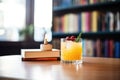 whiskey sour beside vintage cocktail book, bartending theme Royalty Free Stock Photo