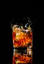 whiskey with splash on black background, brandy in a glass Royalty Free Stock Photo