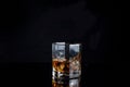 Whiskey splash from the fallen ice cube into glass with beverage isolated on black background Royalty Free Stock Photo