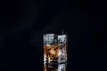 Whiskey splash from the fallen ice cube into glass with beverage isolated on black background Royalty Free Stock Photo