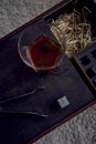 whiskey with tongs, stone cubes, wooden box and wheat on carpet