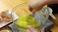 Whisking eggs with sugar in glass bowl