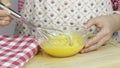 Whisking eggs together in a glass bowl in the kitchen