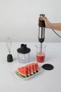 Whisking watermelon in a bowl with immersion hand blender