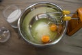 Whisks of electric mixer in front of sugar and eggs in a bowl