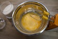 whisks of electric mixer in front of sugar and eggs in a bowl