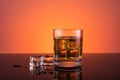 Whisky alcohol in glass with ice drink on orange background Royalty Free Stock Photo