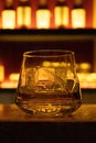 Whisky glass cup with ice on a bar with blur background Royalty Free Stock Photo