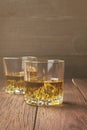 Whisky with ice in two glasses on a wooden background. Toning Royalty Free Stock Photo