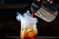 Whisky Smoke. Smoking whiskey with ice and orange on a dark background. Cognac with smoking branch of lavender. Royalty Free Stock Photo