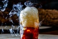 Whisky Smoke. Smoking whiskey with ice and orange on a dark background. Cognac with smoking branch of lavender. Royalty Free Stock Photo