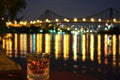 whisky on table, city waterfront with litup bridges beyond Royalty Free Stock Photo