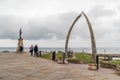 People at Whitby Whale Bones landmark on a cold and windy day