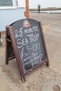 Wooden chalkboard sign advertising tourist sea trips