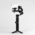 White action camera on three-axis stabilizer. Close up. Isolated on grey background