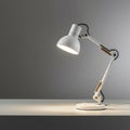 A white, adjustable desk lamp stands on a plain surface.