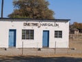 White African village building with two blue doors and hair salon sign