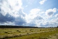 White air clouds in the bright blue sky above the field of mown wheat Royalty Free Stock Photo