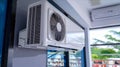 A white air conditioner is securely mounted on a flat surface against a wall. The appliance is positioned to provide