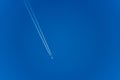 White Airliner with Contrails Flying in a Clear Blue Sky - Photography Royalty Free Stock Photo