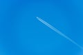 White Airliner with Contrails Flying in a Clear Blue Sky Royalty Free Stock Photo