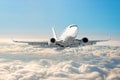 White airplane flies climbs height, flight level high in the sky above the clouds blue sky. Royalty Free Stock Photo