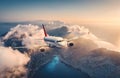 White airplane is flying over mountains and low clouds Royalty Free Stock Photo