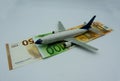 White airplane take off on a pile of Euro banknotes. Aviation concept.