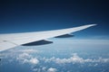 White airplane wing in the blue sky with scattered white clouds Royalty Free Stock Photo