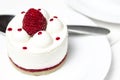 White airy cake with raspberry layer and raspberry berry lies on a white round plate next to a white cup, which stands on a white Royalty Free Stock Photo