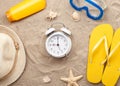 White alarm clock with beach items on sand Royalty Free Stock Photo