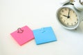 White alarm clock and colorful sticky notes on a white background. The concept of working time. Workplace Royalty Free Stock Photo