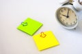 White alarm clock and colorful sticky notes on a white background. The concept of working time. Workplace Royalty Free Stock Photo