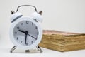 White alarm clock and Old book (Dictionary) on white background Royalty Free Stock Photo