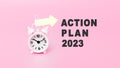 White alarm clock in pink background with text - ACTION PLAN 2023. Concept of Time. Banner with alarm clock