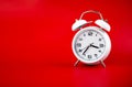 white alarm clock on red background time concept
