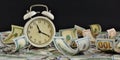 White alarm clock with stacks of dollar bills on a black background close-up.