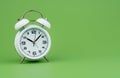 alarm clock tells time working with time importance of time punctuality White clock on a green background