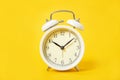 White alarm clock on a yellow background