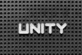 White letter in word unity on black pegboard background Royalty Free Stock Photo