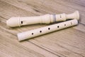 White alto recorder flute on a wooden table, closeup