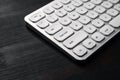 White aluminum computer keyboard on dark wooden office desk